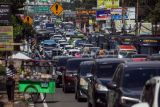 Kepadatan kendaraan wisatawan saat diberlakukan sistem satu arah (one way) pada libur akhir pekan di Jalan Raya Puncak, Gadog, Kabupaten Bogor, Jawa Barat, Sabtu (2/3/2024). Kementerian Pekerjaan Umum dan Perumahan Rakyat (PUPR) mengkaji rencana pembangunan jalan tol Puncak di Jawa Barat untuk solusi mengurai kemacetan dengan mempertimbangkan berbagai faktor, termasuk kawasan lindung, permukiman, dan keseimbangan antara lingkungan, ekonomi, dan sosial. ANTARA FOTO/Yulius Satria Wijaya/wpa.
