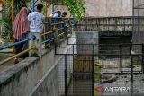 Wisatawan memperhatikan buaya (Crocodylus porosus) yang berada di kandang di Taman Satwa Cikembulan, Kabupaten Garut, Jawa Barat, Minggu (3/3/2024). Kementerian Pariwisata dan Ekonomi Kreatif menargetkan sebanyak 1,2 hingga 1,5 miliar pergerakan wisatawan di seluruh nusantara pada 2024. ANTARA FOTO/Raisan Al Farisi/agr