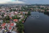 Foto udara Situ Cilodong yang dikelilingi pemukiman di Kota Depok, Jawa Barat, Senin (4/3/2024). Ruang Terbuka Biru (RTB) selain memiliki fungsi vital sebagai pencegah banjir di kala penghujan dan lumbungnya air saat kemarau, juga dimanfaatkan sebagai area wisata dengan konsep alam. ANTARA FOTO/Yulius Satria Wijaya/Spt.