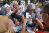 Petugas melayani para jamaah calon haji lanjut usia (lansia) asal Banda Aceh saat mengikuti tes kebugaran jasmani di kawasan Universitas Syiah Kuala (USK) Student Park, Banda Aceh, Aceh, Rabu (6/3/2024).  Tes kebugaran jasmani dengan metode jalan Rockport yang diikuti 300 orang Jamaah Calon Haji (JCH) lansia Kota Banda Aceh bertujuan untuk mengetahui ketahanan dan kekuatan fisik jamaah sebelum melaksanakan berbagai aktivitas ibadah haji di Tanah Suci. ANTARA FOTO/Khalis Surry
