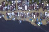 Foto udara kawasan permukiman yang terendam banjir di tepi Sungai Kumpeh, Suak Kandis, Muaro Jambi, Jambi, Selasa (5/3/2024). Banjir luapan Sungai Batanghari yang merendam ratusan rumah di kawasan itu sejak pertengahan Desember tahun lalu masih belum berakhir hingga kini, sementara kegiatan belajar mengajar langsung di sejumlah sekolah masih diliburkan sehingga warga berharap pemerintah bisa mencarikan solusi untuk pendidikan anak-anak mereka. ANTARA FOTO/Wahdi Septiawan/nym.
