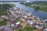 Foto udara kawasan permukiman yang terendam banjir di tepi Sungai Kumpeh, Suak Kandis, Muaro Jambi, Jambi, Selasa (5/3/2024). Banjir luapan Sungai Batanghari yang merendam ratusan rumah di kawasan itu sejak pertengahan Desember tahun lalu masih belum berakhir hingga kini, sementara kegiatan belajar mengajar langsung di sejumlah sekolah masih diliburkan sehingga warga berharap pemerintah bisa mencarikan solusi untuk pendidikan anak-anak mereka. ANTARA FOTO/Wahdi Septiawan/nym.