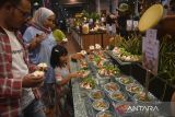 Pengunjung menikmati berbagai hidangan makanan untuk menu berbuka puasa saat Iftar Dinner Arabian Night di  resto Rain Forest, Taman Safari Indonesia (TSI), Cisarua, Kabupaten Bogor, Jawa Barat, Sabtu (9/3/2024). Menyambut datangnya bulan suci Ramadan 1445 Hijriyah, TSI Bogor menggelar Iftar Dinner Arabian Night yang menyajikan beragam menu kuliner untuk buka puasa bersama keluarga dan free menonton aksi teatrikal seru seperti fire dance hingga live music mulai 16 Maret hingga 7 April. ANTARA FOTO/Arif Firmansyah