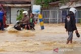 Warga melintasi banjir dengan berjalan kaki dan menggunakan motor 