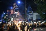 Sejumlah pemuda mengarak Ogoh-Ogoh saat parade Ogoh-ogoh di Hari Pengerupukan atau satu hari menjelang Hari Raya Nyepi Tahun Saka 1946 di kawasan Desa Adat Kuta, Badung, Bali, Minggu (10/3/2024). Kegiatan yang juga disaksikan ribuan warga dan wisatawan baik domestik serta mancanegara tersebut dilakukan untuk menetralisir unsur negatif agar perayaan Nyepi dapat dilaksanakan dengan damai sekaligus untuk mengapresiasi kreativitas seni budaya para pemuda. ANTARA FOTO/Widodo S Jusuf/wsj.