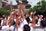 Puluhan warga saling berebut menangkap uang yang dilemparkan warga lainnya saat tradisi Mesuryak di Desa Bongan Gede, Tabanan, Bali, Sabtu (9/3/2024). Tradisi yang digelar setiap Hari Raya Kuningan sebagai rasa suka cita untuk mengantarkan roh para leluhur kembali ke surga tersebut disaksikan wisatawan domestik dan mancanegara yang berkunjung ke desa itu. ANTARA FOTO/Nyoman Hendra Wibowo/wsj.