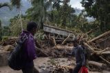 Warga melintas di dekat jembatan yang putus akibat banjir bandang di Langgai, Gantiang Mudiak Utara Surantiah, Kecamatan Sutera, Pesisir Selatan, Sumatera Barat, Selasa (12/3/2024). Akses menuju lokasi bencana tersebut putus dan warga yang terdampak mengharapkan bantuan berupa kebutuhan untuk ibu dan anak serta perbaikan jaringan listrik yang terputus ke desa mereka. ANTARA FOTO/Givo Alputra/Lmo/aww. 