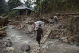 Warga memanggul karung berisi bantuan untuk korban banjir bandang dan longsor di Langgai, Gantiang Mudiak Utara Surantiah, Kecamatan Sutera, Pesisir Selatan, Sumatera Barat, Selasa (12/3/2024). Akses menuju lokasi bencana tersebut putus dan warga yang terdampak mengharapkan bantuan berupa kebutuhan untuk ibu dan anak serta perbaikan jaringan listrik yang terputus ke desa mereka. ANTARA FOTO/Givo Alputra/Lmo/aww. 