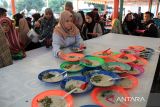 Petugas membagikan bubur pedas kepada warga yang berbuka puasa di Masjid Raya Al-Mashun, Medan, Sumatera Utara, Selasa (12/3/2024). Pengurus Masjid Raya Medan menyiapkan sebanyak 500 porsi bubur pedas gratis yang dibagikan kepada masyarakat selama bulan Ramadhan.ANTARA FOTO/Yudi  Manar/