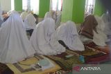 Jemaah perempuan berzikir dan membaca doa saat mengikuti ibadah  suluk di Dayah Darul Aman, Desa Lampuuk, Kabupaten Aceh Besar, Aceh, Rabu  (13/3/2024). Aktivitas spritual suluk pada bulan Ramadhan 1445 Hijriyah diikuti jamaah laki laki dan perempuan di pesatren tersebut memperbanyak dzikir, shalat sunah, dan ibadah lainnya yang bertujuan membersihkan hati dan menyucikan jiwa serta mendekatkan diri kepada Allah SWT.  ANTARA FOTO/Ampelsa.