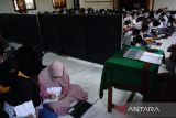 Santri mengikuti kajian kitab kuning dengan menggunakan terjemahan bahasa Inggris dan Jawa atau bilingual di Pesantren Al Aqobah Jombang, Jawa Timur, Sabtu (16/3/2024). Penggunaan bahasa Inggris dalam menerjemahkan kitab kuning tersebut sebagai bentuk untuk melatih para santri membiasakan dalam berbahasa asing, dan mempercepat hafalan mufrodat atau kosa katanya. Sehingga nantinya para santri bisa bersaing di dunia Internasional. Antara Jatim/Syaiful Arif/rf