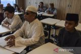 Penyandang disabilitas tunanetra membaca Al Quran Braille saat kegiatan tadarus di Tasikmalaya, Jawa Barat, Minggu (17/3/2024). Yayasan Majelis Taklim Tuna Netra Al-Hikmah menggelar tadarus Al Quran Braille kepada penyandang disabilitas  tunanetra di tempat makan siap saji dalam mengisi waktu menunggu berbuka puasa atau ngabuburit. ANTARA FOTO/Adeng Bustomi/agr