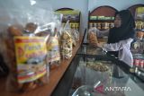 Pekerja menunjukkan logo halal yang tertera pada produk Kerupuk Tuiri binaan Bank Indonesia perwakilan Bengkulu di salah satu gerai penjualan oleh-oleh khas Bengkulu di Kota Bengkulu, Sabtu (16/3/2024). Menurut pelaku UMKM di wilayah tersebut geliat permintaan aneka cemilan dalam bulan Ramadhan 1445 Hijriah meningkat hingga 100 persen dari biasanya dengan harga jual Rp25 ribu per kemasan. ANTARA/Muhammad Izfaldi