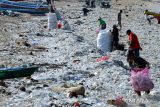 Warga memungut sampah plastik yang berserakan di kawasan Pantai Kedonganan, Badung, Bali, Rabu (20/3/2024). Pantai Kedonganan dipadati sampah plastik kiriman yang terdampar terbawa arus laut yang mengganggu aktivitas warga dan nelayan setempat. ANTARA FOTO/Fikri Yusuf/wsj.