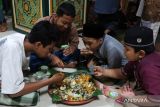 Umat Islam makan bersama dalam satu wadah saat berbuka puasa pada tradisi Megibung di Masjid Al-Muhajirin, Kampung Islam Kepaon, Denpasar, Bali, Kamis (21/3/2024). Tradisi makan bersama khas adat masyarakat Bali tersebut digelar tiga kali selama bulan puasa Ramadhan untuk memperkuat rasa persaudaraan. ANTARA FOTO/Nyoman Hendra Wibowo/wsj.