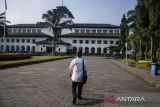 Pegawai berjalan di area parkiran saat pemberlakuan Jumat bebas kendaraan bermotor (Friday Car Free) di Gedung Sate, Bandung, Jawa Barat, Jumat (22/3/2024). Pemprov Jawa Barat memberlakukan kebijakan bebas kendaraan bermotor setiap Jumat di lingkungan Gedung Sate bagi seluruh pegawai, ASN, dan masyarakat yang bertujuan memaksimalkan moda transportasi umum serta diharapkan terjadi penurunan volume kendaraan di Kota Bandung. ANTARA FOTO/Novrian Arbi/agr