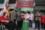 Pj Wali Kota Banda Aceh Amiruddin (keempat kiri) didampingi Ketua Yayasan Hakka Aceh Kho Kie Siong (ketiga kiri) saat menyalurkan bantuan paket sembako Ramadhan kepada warga kurang mampu di Desa Peunayong, Banda Aceh, Aceh, Sabtu (23/3/2024). Etnis Tionghoa berdomisili di Aceh yang tergabung dalam Yayasan Hakka menyalurkan 2.160 paket bantuan sembako Ramadhan 1445 H bagi umat muslim kurang mampu dalam upaya membantu memenuhi kebutuhan saat menjalani ibadah puasa serta memperkuat wujud toleransi beragama dalam kehidupan bermasyarakat. ANTARA FOTO/Khalis Surry