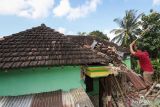 Warga membongkar rumahnya yang rusak akibat gempa di Desa Suwari, Sangkapura, Pulau Bawean, Gresik, Jawa Timur, Minggu (24/3/2024). Badan Penanggulangan Bencana Daerah (BPBD) Gresik mencatat sebanyak 4.085 rumah, 138 rumah ibadah, 68 sekolah, dan 12 perkantoran di Kecamatan Sangkapura dan Tambak mengalami kerusakan akibat gempa bumi yang berpusat di Kabupaten Tuban, Jawa Timur. ANTARA jatim/Rizal Hanafi/rf