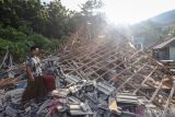 Warga berada di samping rumah yang mengalami kerusakan akibat gempa di Dusun Prapat Tunggal, Sangkapura, Pulau Bawean, Gresik, Jawa Timur, Minggu (24/3/2024). Badan Penanggulangan Bencana Daerah (BPBD) Gresik mencatat sebanyak 4.085 rumah, 138 rumah ibadah, 68 sekolah, dan 12 perkantoran di Kecamatan Sangkapura dan Tambak mengalami kerusakan akibat gempa bumi yang berpusat di Kabupaten Tuban, Jawa Timur. ANTARA jatim/Rizal Hanafi/Spt.