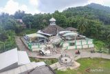 Warga melintas di dekat Masjid Jamik Al Muhajirin yang sebangian bangunannya roboh akibat gempa di Dusun Balikbakgunung, Sangkapura, Pulau Bawean, Gresik, Jawa Timur, Minggu (24/3/2024). Badan Penanggulangan Bencana Daerah (BPBD) Gresik mencatat sebanyak 4.085 rumah, 138 rumah ibadah, 68 sekolah, dan 12 perkantoran di Kecamatan Sangkapura dan Tambak mengalami kerusakan akibat gempa bumi yang berpusat di Kabupaten Tuban, Jawa Timur. ANTARA jatim/Rizal Hanafi/Spt