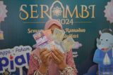 Warga memperlihatkan uang pecahan baru saat kegiatan Semarak Rupiah Ramadhan dan Berkah Idul Fitri (Serambi) 2024 di Taman Budaya, Banda Aceh, Aceh, Senin (25/3/2024). Program Serambi 2024 Bank Indonesia di Provinsi Aceh menyiapkan uang pencahan baru Rp5,4 triliun untuk memberi kemudahan bagi masyarakat dalam mendapatkan uang pencahan baru untuk kebutuhan Lebaran pada 25 Maret - 5 April 2024. ANTARA FOTO/Khalis Surry
