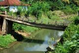 Jembatan ambrol tergerus banjir. Warga terpaksa menyeberangi sungai tak jauh dari jembatan yang ambrol tergerus banjir di Desa Kalidawir, Tulungagung, Jawa Timur, Minggu (24/3/2024). Pondasi di kedua sisi/ujung jembatan penghubung desa itu amblas tergerus luapan air yang membanjiri daerah itu sehingga menyebabkan badan jembatan patah dan turun sekitar 50 centimeter sehingga tidak bisa dilalui  kendaraan. ANTARA Jatim/Destyan Sujarwoko/rf