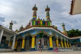 Anak-anak bermain di area Masjid Hidayatunnas di Desa Sirnagalih, Kecamatan Cisurupan, Kabupaten Garut, Jawa Barat, Minggu (24/3/2024). Masjid Hidayatunnas yang dibangun sejak 20 tahun lalu tersebut memiliki corak warna-warni di bagian dalam maupun luar masjid yang menjadi keunikan dan ciri khasnya. ANTARA FOTO/Raisan Al Farisi/agr