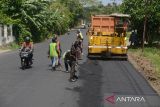 Pekerja menggunakan alat berat mengaspal badan jalan saat perbaikan di jalur jalan nasional Banda Aceh-Medan, desa Montasik, kabupaten Aceh Besar, Aceh, Senin (25/3/2024). Perbaikan dan perawatan jalan nasional di sejumlah titik provinsi Aceh itu untuk nmemberikan keamanan,  kenyamanan dan kelancaran bagi penguguna jalan, khususnya pada  arus mudik  Idul Fitri 2024. ANTARA FOTO/Ampelsa.