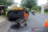 Pekerja menggunakan alat berat mengaspal  badan jalan di jalur jalan nasional Banda Aceh-Medan, desa Montasik, kabupaten Aceh Besar, Aceh, Senin (25/3/2024). Perbaikan dan perawatan jalan nasional di sejumlah titik provinsi Aceh itu untuk memberikan keamanan,  kenyamanan dan kelancaran bagi penguguna jalan, khususnya pada  arus mudik  Idul Fitri 2024. ANTARA FOTO/Ampelsa.