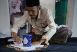Permintaan karya seni kaligrafi meningkat. Seniman membuat karya seni kaligrafi tiga dimensi (kaligrafi timbul) di atas kain bludru warna hitam untuk replika kiswah (penutup ka'bah) di rumahnya di Tulungagung, Jawa Timur, Minggu (24/3/2024). Permintaan karya seni kaligrafi yang dijual mulai Rp75 ribu hingga puluhan juta rupiah selama Ramadan atau menjelang Lebaran ini meningkat dibanding bulan-bulan sebelumnya, yakni dari biasanya hanya 3-4 pemesanan per bulan kini sudah mencapai belasan hanya dalam dua pekan Ramadan ini. ANTARA Jatim/Destyan Sujarwoko/rf
