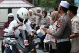 KB Samsat Surabaya Utara bagi takjil. Polisi dan pegawai membagikan takjil kepada pengendara motor di Kantor Bersama (KB) Samsat Surabaya Utara, Surabaya, Jawa Timur, Senin (25/3/2024). KB Samsat Surabaya Utara membagikan sekitar 300 bungkus takjil kepada pengendara motor maupun pengendara sepeda angin yang kebetulan melintas di depan kantor itu untuk memberikan hidangan sebagai pembuka puasa kepada mereka. Antara Jatim/Didik SuhartonoANTARA FOTO/Didik Suhartono (ANTARA FOTO/Didik Suhartono)