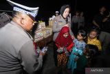 Anggota polisi memberikan hadiah kepada anak-anak korban gempa Bawean saat bakti sosial di Posko Pengungsian Suwari, Sangkapura, Pulau Bawean, Gresik, Jawa Timur, Senin (25/3/2024). Bakti sosial tersebut diisi dengan memberikan layanan kesehatan gratis, kegiatan trauma healing serta memberikan paket bantuan berupa sembako dan selimut guna membantu percepatan penanggulangan bencana gempa bumi di Pulau Bawean. Antara Jatim/Rizal Hanafi