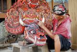 Perajin melakukan pewarnaan pada mahkota barongan atau topeng kepala naga hasil karya seninya di rumah produksi barongan Desa Jatimulyo, Tulungagung, Jawa Timur, Salasa (26/3/2024). Topeng kepala naga atau dalam bahasa Jawa disebut dengan istilah barongan itu dijual di kisaran Rp4 juta hingga Rp6 juta, bergantung jenis bahan, ukuran dan tingkat kerumitan ukiran wajah serta pernik hiasan yang melekat pada bagian kepala barong. ANTARA Jatim/Destyan Sujarwoko