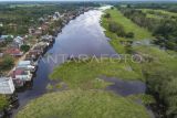 Foto udara sebuah kapal terseret tumpukan gulma atau rumput kumpeh yang hanyut terbawa arus Sungai Kumpeh di Suak Kandis, Kumpeh, Muaro Jambi, Jambi, Senin (25/3/2024). Belasan rumah di bantaran Sungai Kumpeh tersebut roboh akibat terseret tumpukan gulma yang hanyut terbawa arus sungai itu. ANTARA FOTO/Wahdi Septiawan/YU