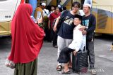 Santri asal Bali yang menjalani pendidikan di Pondok Pesantren Darussalam Blokagung, Banyuwangi, Jawa Timur berfoto dengan keluarganya setibanya di Terminal Mengwi, Badung, Bali, Kamis (28/3/2024). Sekitar 500 orang santri asal Bali itu melakukan perjalanan mudik lebih awal pada masa liburan Hari Raya Idul Fitri 1445 Hijriah. ANTARA FOTO/Fikri Yusuf/wsj.