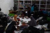 Peningkatan produk konveksi jelang lebaran di Madiun. Sejumlah pekerja mengemas pakaian di sebuah industri rumahan konveksi di Mancaan, Jiwan, Kabupaten Madiun, Jawa Timur, Rabu (27/3/2024). Industri rumahan konveksi yang memproduksi pakaian wanita dan anak-anak tersebut meningkatkan produksinya hingga sekitar 100 persen dari 125 menjadi 250 potong pakaian per hari guna memenuhi permintaan pakaian untuk lebaran yang dipasarkan melalui pasar digital dengan harga Rp25.000-Rp190.000 per potong. Antara Jatim/Siswowidodo