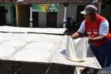 Produksi kue manco jelang lebaran di Madiun. Pekerja menjemur adonan tepung ketan untuk bahan kue manco di sebuah industri rumahan di Tambakmas, Kebonsari, Kabupaten Madiun, Jawa Timur, Kamis (28/3/2024). Industri rumahan tersebut menaikkan jumlah produksi dari sebelumnya sebanyak 400-500 kemasan menjadi 800-1.000 kemasan per hari guna memenuhi peningkatan permintaan kue untuk lebaran dan dijual dengan harga Rp6 ribu-Rp10 ribu per kemasan. Antara Jatim/Siswowidodo