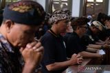 Umat Katolik yang mengenakan busana adat Bali melaksanakan ibadah Jumat Agung di Gereja Katolik Paroki Roh Kudus Babakan, Desa Canggu, Badung, Bali, Jumat (29/3/2024). Prosesi cium salib yang merupakan rangkaian peringatan Tri Hari Suci Paskah tersebut sebagai bentuk penghormatan terakhir kepada Yesus yang rela mati di kayu salib untuk menebus dosa umat manusia. ANTARA FOTO/Nyoman Hendra Wibowo/wsj.