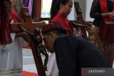 Umat Katolik yang mengenakan busana adat Bali melaksanakan prosesi cium salib dalam ibadah Jumat Agung di Gereja Katolik Paroki Roh Kudus Babakan, Desa Canggu, Badung, Bali, Jumat (29/3/2024). Prosesi cium salib yang merupakan rangkaian peringatan Tri Hari Suci Paskah tersebut sebagai bentuk penghormatan terakhir kepada Yesus yang rela mati di kayu salib untuk menebus dosa umat manusia. ANTARA FOTO/Nyoman Hendra Wibowo/wsj.