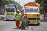 Pekerja menyelesaikan proses pengecatan marka jalan di jalur pantura Lohbener Indramayu, Jawa Barat, Senin (1/4/2024). Pengecatan marka jalan tersebut guna peningkatan keselamatan berlalu lintas terutama saat mudik Lebaran. ANTARA FOTO/Dedhez Anggara/agr
