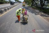 Pekerja menyelesaikan proses pengecatan marka jalan di jalur pantura Lohbener Indramayu, Jawa Barat, Senin (1/4/2024). Pengecatan marka jalan tersebut guna peningkatan keselamatan berlalu lintas terutama saat mudik Lebaran. ANTARA FOTO/Dedhez Anggara/agr
