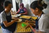 Pekerja menyelesaikan pembuatan kue kering di industri rumahan Ika Cokies, Medan, Sumatera Utara, Rabu (3/4/2024). Menurut pemilik usaha, menjelang Lebaran permintaan kue kering yang dijual dengan harga Rp45.000  hingga Rp75.000 per stoples tersebut meningkat sekitar 60 persen dibanding tahun kemarin. ANTARA FOTO/Fransisco Carolio