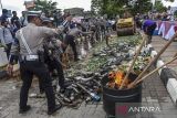 Polisi memusnahkan minuman beralkohol dan knalpot brong usai Apel Gelar Pasukan Operasi Ketupat Lodaya di Alun-alun Ciamis, Jawa Barat, Rabu (3/4/2024). Polres Ciamis memusnahkan barang bukti hasil Operasi Keselamatan dan Pekat Lodaya selama Ramadhan 2024 sebanyak 1.002 botol minuman beralkohol, obat psikotropika 10.927 butir, ganja 177 gram, 45 sachet jamu berbagai merek, dan 719 knalpot brong. ANTARA FOTO/Adeng Bustomi/agr