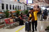 Porter membawakan barang penumpang yang turun dari Kereta Api (KA) Gajayana Tambahan Lebaran relasi Stasiun KA Gambir-Malang saat transit di Stasiun KA Madiun, Jawa Timur, Jumat (5/4/2024). Pada hari pertama masa Posko Angkutan Lebaran KAI tersebut ratusan penumpang mudik awal turun di Stasiun KA Madiun. Antara Jatim/Siswowidodo/um