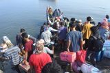 Sejumlah warga antre menaiki perahu penghubung untuk ke perahu motor di Pelabuhan Kalbut, Situbondo, Jawa Timur, Sabtu (6/4/2024). Warga Pulau Sapudi, Sumenep terpaksa mudik menggunakan perahu motor meskipun peralatan keselamatan penumpang minim dan kehabisan tiket kapal motor penumpang di Pelabuhan Jangkar. Antara Jatim/Seno/mas.