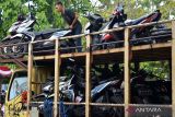 Pekerja menyusun sepeda motor pemudik Lebaran 2024 di atas truk pengangkut di Denpasar, Bali, Sabtu (6/4/2024). Pengangkutan sepeda motor pemudik secara gratis menuju Banyuwangi, Jawa Timur itu selain sebagai upaya untuk mengurangi angka kecelakaan selama periode mudik Lebaran 2024, juga mengurangi kepadatan lalu lintas di jalur mudik. ANTARA FOTO/Fikri Yusuf/wsj.