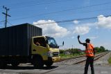 Seorang relawan memandu pengendara di perlintasan Kereta Api (KA) sebidang di Ngetrep, Jiwan, Kabupaten Madiun, Jawa Timur, Sabtu (6/4/2024). Saat ini di wilayah PT KAI Daerah Operasi (Daop) 7 Madiun masih terdapat 60 perlintasan KA sebidang yang belum dijaga atau belum berpalang pintu, dan hanya dijaga oleh warga sekitar secara sukarela dengan mendapatkan imbalan dari para pengendara yang lewat. Antara Jatim/Siswowidodo/mas.