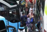 Sejumlah pemudik berjalan menuju bus saat Mudik Bareng Gratis di Jalan Ahmad Yani, Surabaya, Jawa Timur, Minggu (7/4/2024). Pemerintah Provinsi Jawa Timur memberangkatkan 96 bus gratis dengan 3.840 pemudik yang pulang ke kampung halamannya untuk merayakan Lebaran 2024. Antara Jatim/Didik Suhartono/um