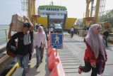 Penumpang berjalan turun dari Kapal Motor Penyeberangan (KMP) BRR saat tiba dari Kota Sabang di Pelabuhan Penyeberangan Ulee Lheu, Banda Aceh, Aceh, Minggu (7/4/2024). PT ASDP Indonesia Ferry Cabang Banda Aceh menyatakan arus mudik menjelang Idul Fitri 1445 H di Pelabuhan Ulee Lheu terpantau normal dan lancar dengan rata-rata 1.200 - 1.500 penumpang per hari, dan diprediksikan akan terjadi lonjakan pada H Lebaran hingga H+4 Lebaran dengan estimasi 5.000 penumpang per hari yang didominasi wisatawan tujuan Pulau Weh, Sabang. ANTARA FOTO/Khalis Surry
