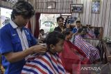 Pemangkas rambut mencukur rambut pelanggan di Kabupaten Ciamis, Jawa Barat, Minggu (7/4/2024). Jelang Lebaran pelaku usaha jasa pangkas rambut bisa melayani sekitar 200 pelanggan yang dikerjakan oleh lima karyawan dengan omzet mencapai Rp3 juta - Rp4 juta per hari. ANTARA FOTO/Adeng Bustomi/agr